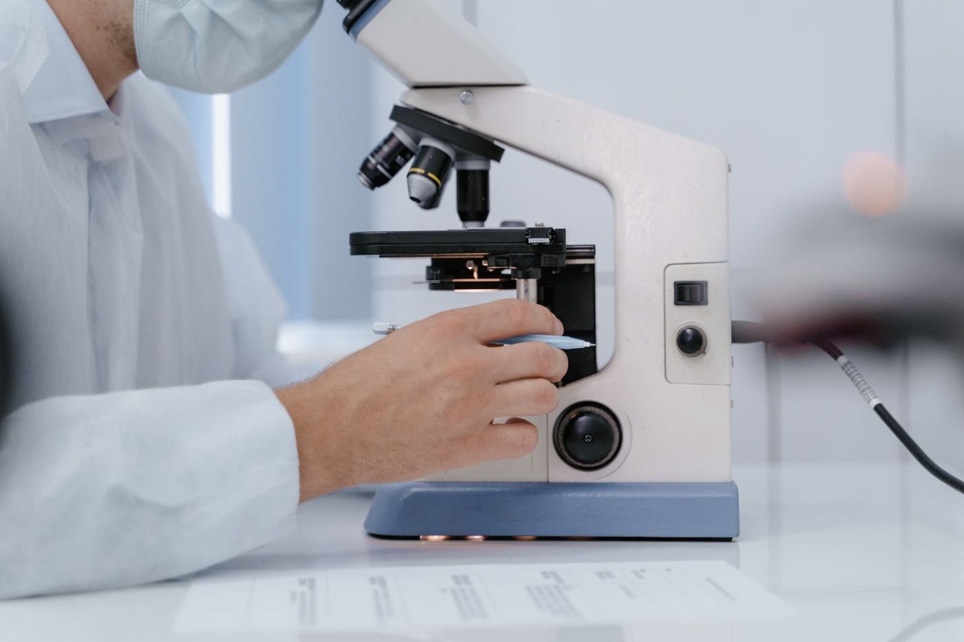 Researcher adjusting a laboratory microscope