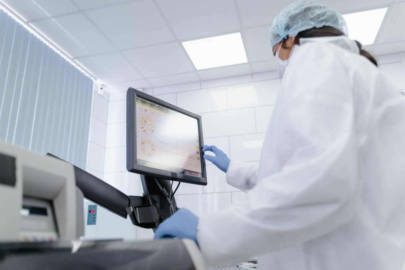 Laboratory technician reading assay data on a monitor